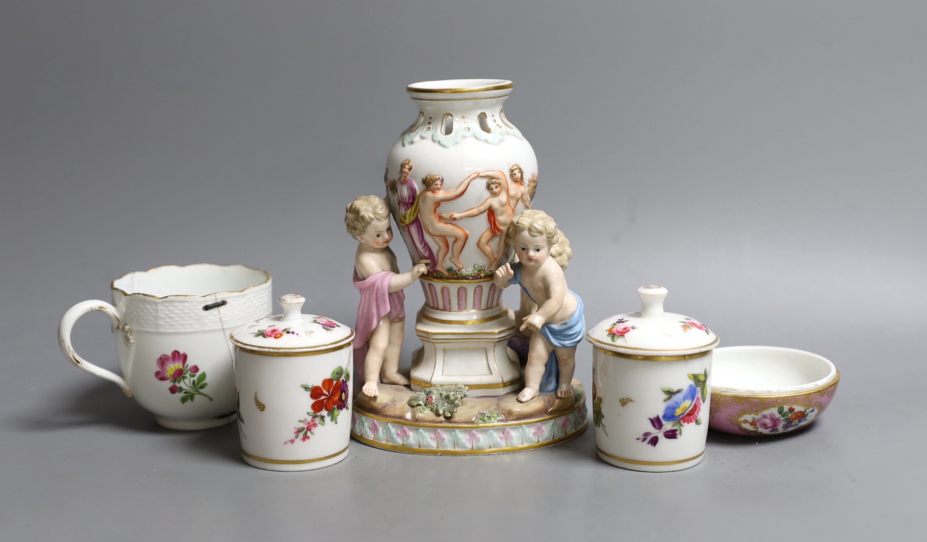 A Meissen cherub centrepiece, a similar cup and box base, together with two Meissen style jars and covers, centrepiece 16 cms high